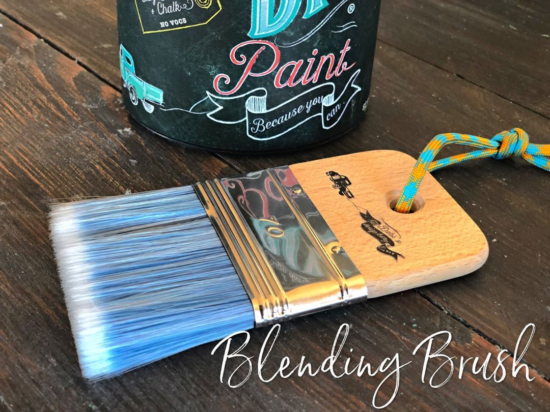 Synthetic flat blending brush laying next to DIY Paint